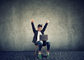 Successful guy with laptop excited with win