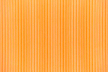 Backdrop textured paper of orange cardboard with vertical corrugated lines.
