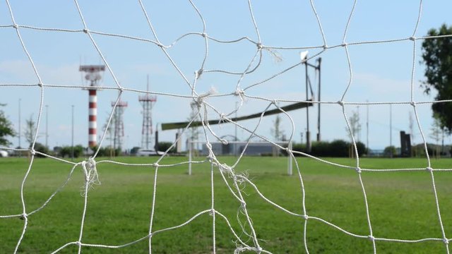 Porte di calcio e sullo sfondo l'aeroporto di Milano Linate