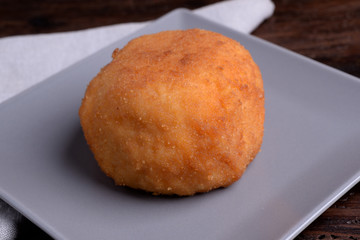 Arancina with meat on gray plate 