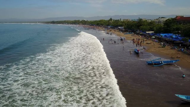 Aerial view of crowded beach with classic fishing vessels and holidaymakers in Pangandara, Indonesia