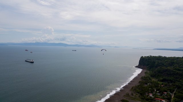 Beautiful aerial view of the beach with parapenting in the horizon