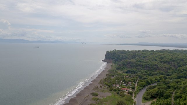 Beautiful aerial view of the beach with parapenting in the horizon