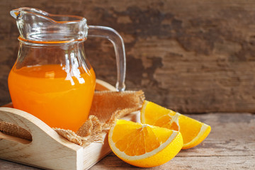 Naklejka na ściany i meble Orange and orange juice on wooden background