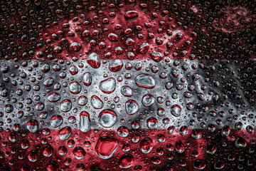 Close-up of a drop of water against a background of the national flag of Austria   on an isolated background