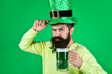 St. Patrick's Day. Bearded man in leprechaun hat. Portrait of pensive man with green beer. Bearded...
