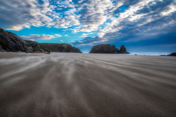 Beautiful and dramatic beach scene in Bandon Oregon with wind being blown across the surface