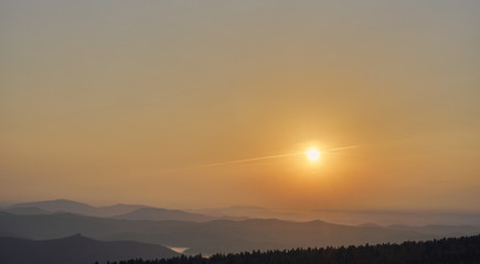 Dawn and sun over mountain range in summer