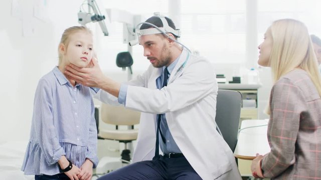 Mother with a Little Daughter Visit Doctor. Friendly ENT Pediatrician Checks Ears of a Little Smiling Girl. Shot on RED EPIC-W 8K.