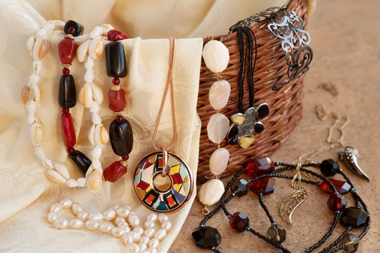 A lot of different jewelry. Bijouterie of different kinds on a wicker box. Fashion, style and accessories for women.