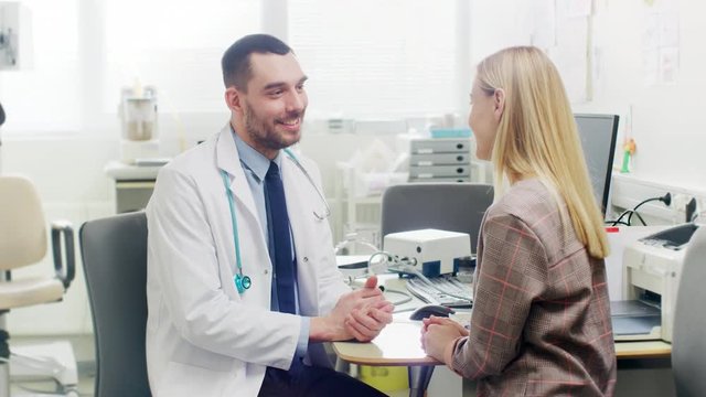 In Medical Office Friendly Doctor Talks with a Beautiful Blonde Woman. Health Care Professional Consultation in the Bright Modern Office. Shot on RED EPIC-W 8K Helium Cinema Camera.