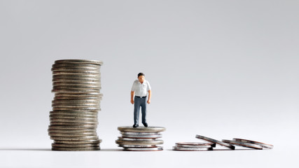 Concept of increase in basic cost of living in old age. The stack of coins with miniature people.