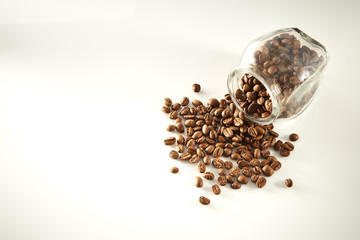 roasted coffee beans poured from clear glass