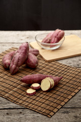 Raw sweet potato on wooden table