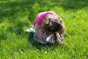 Little girl playing at the green lawn