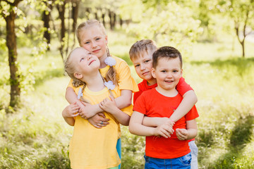 Fototapeta na wymiar four fun happy kids hugging outdoors