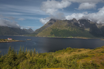 House on the shore with view to snow mountain and  sea in the Norway at summer