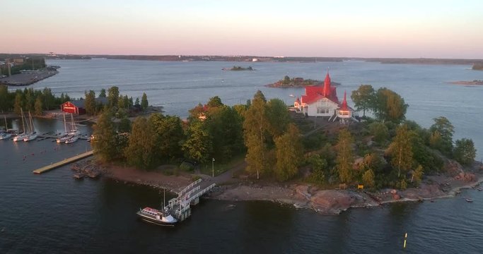 Helsinki archipelago, C4K aerial sideway view of luoto and valkosaari islands, in the south harbor bay, on a sunny summer evening dusk, in Helsingfors, Uusimaa, Finland