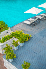 Beautiful luxury umbrella and chair around swimming pool in hotel and resort