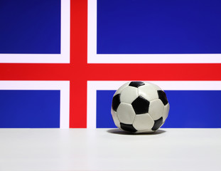 Obraz premium Small football on the white floor and red and white color of cross on blue of Iceland nation flag background. The concept of sport.