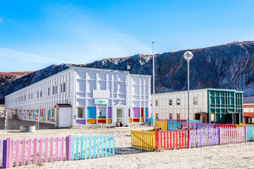 Modern greenlandic kindergarten with playground and colorful fen