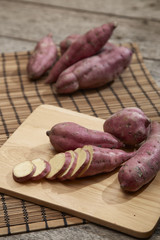 Raw sweet potato on wooden table