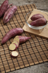 Raw sweet potato on wooden table