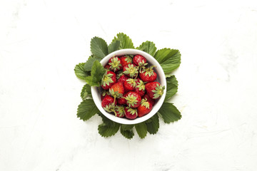 Strawberries in a white bowl on a light background. Red Juicy Strawberry. Flat lay, top view.