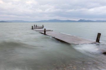 Pier on Trasimeno lake at Castiglione del Lago (Umbria), with mo