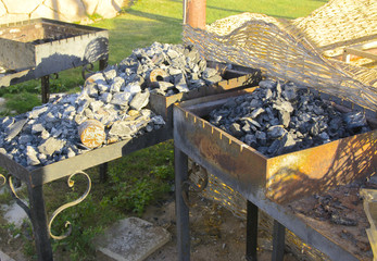 Old abandoned rusty braziers on an empty seashore against a background of yellow sand and blue sky. Thrown, unnecessary things. Vacation, tourism.