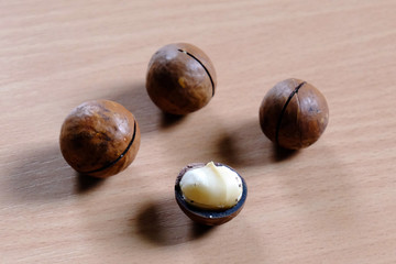 Obraz premium Macadamia nuts in shell on wooden table