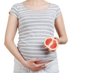 Pregnant woman with a grapefruit in the hand