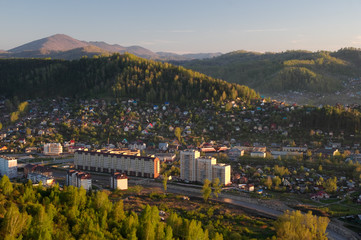 Green mountain landscape with illuminated sunset light town village valley among hills