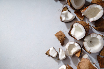 Cracked coconut on gray background with copy space. Food or cosmetics ingredient