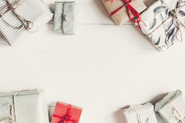 christmas flat lay. wrapped present boxes on white wooden background top view, space for text.  seasonal greetings card. happy holidays. merry christmas concept