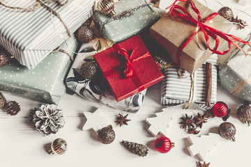 merry christmas concept. presents with ornaments pine cones anise and lights on rustic white wooden background top view, space for text. seasonal greetings card. happy holiday