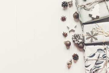 merry christmas concept. stylish modern presents with ornaments cones anise on  rustic white wooden background top view, space for text. seasonal greetings. happy holidays. xmas flat lay