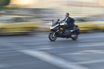 Fototapeta na wymiar capture de mouvement (filé) sur une moto sans casque grecque à athènes