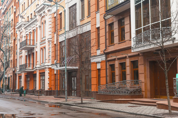 classic and modern orange houses in a winter street with puddles