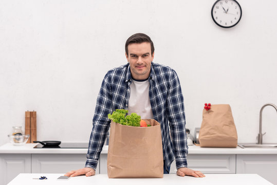 Handsome Adult Man With Grocery Store Paper Bag At Kitchen