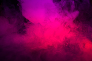 Fototapeta na wymiar Colored purple and red smoke on a black background closeup