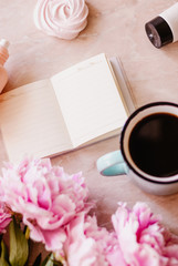 Beauty flat lay with a diary, cup of coffee, accessories and peonies on a marble background