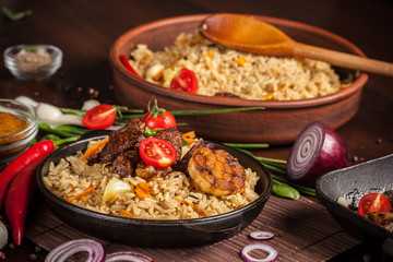The concept of oriental cuisine. Homemade Uzbek pilaf from lamb served in cast iron cookware. Copy space.
