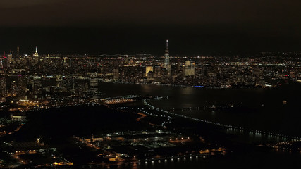 Fototapeta na wymiar AERIAL: Stunning shimmering New Jersey and Downtown Manhattan skyline at night