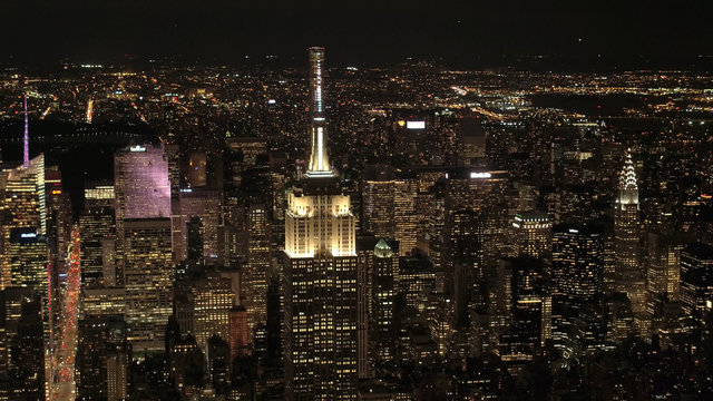 AERIAL: Empire State Building at night looking toward Upper Manhattan & Queens