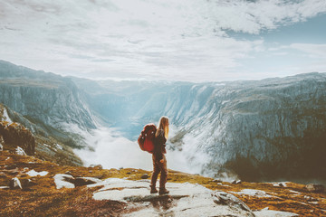 Solo traveling girl hiking with backpack in mountains adventure journey lifestyle vacations weekend getaway in Norway