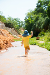 kid is running in river of mui ne fairy stream, making a fist
