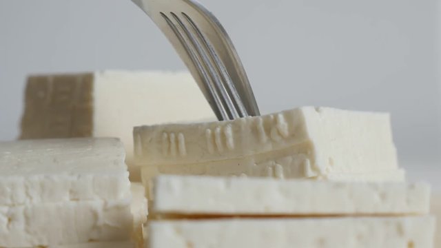Piece of cow milk cheese taking with fork slow motion video