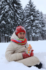 The frame depicts a winter forest, trees and pine trees. A child is playing with snow. Walk in the winter forest on vacation.