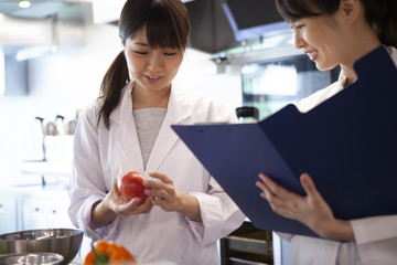 Obraz premium 栄養士たちが野菜の栄養素について調べている